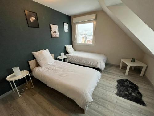 2 Betten in einem kleinen Zimmer mit einer Treppe in der Unterkunft Sérénité alsacienne in Seltz