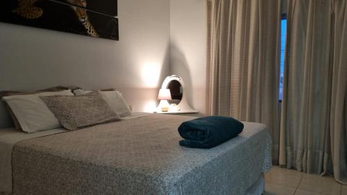 Un dormitorio con una cama con una almohada azul. en Apartamento Confortável e Espaçoso, en Sinop