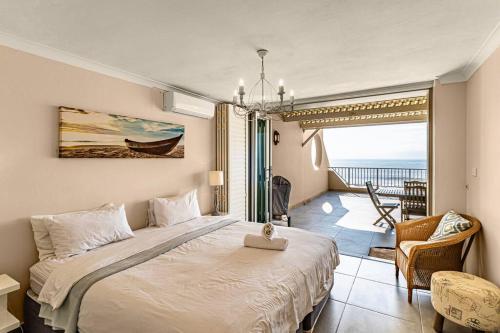 a bedroom with a bed and a view of the ocean at Sunny Beach Front Apartment in Ballito