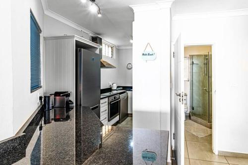 a kitchen with a stainless steel refrigerator in a room at Sunny Beach Front Apartment in Ballito