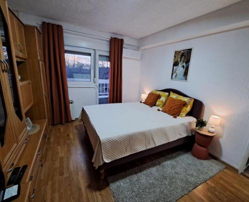 Kostolac的住宿－Apartment White Angel，卧室配有白色的床和窗户。