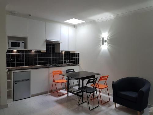 uma cozinha com uma mesa e cadeiras e uma luz em Contemporary ground flr maisonette- Entire place em Northwood