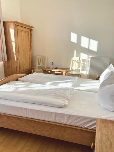 um quarto com 2 camas e lençóis brancos em Hotel Fokus em Emsbüren