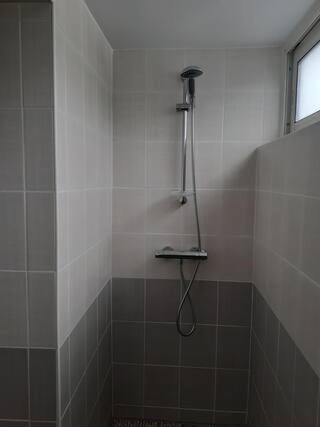 y baño con ducha con cabezal de ducha. en Appartement neuf et cosy, en Cambo-les-Bains