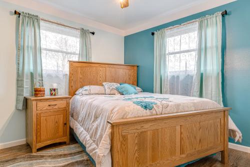 a bedroom with a bed with blue walls and windows at Cozy Richmond Home with Fire Pit Walk, Bike and More! in Richmond