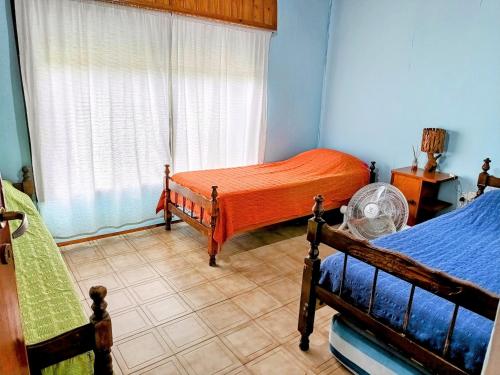 sypialnia z 2 łóżkami i oknem w obiekcie La Casa de Las Flores Potrero de los Funes w mieście Potrero de los Funes