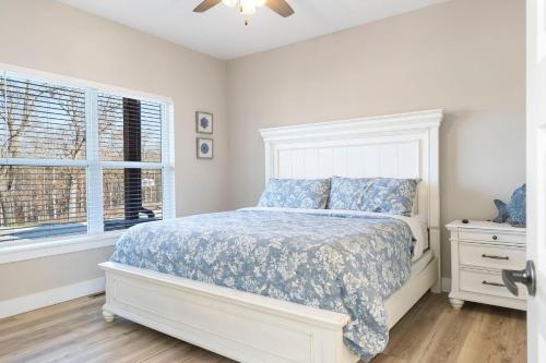 a white bedroom with a bed and a window at Timber's Edge in Kimberling City