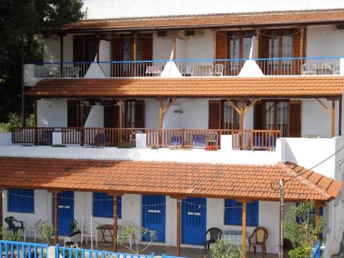 a building with blue doors and brown roof at Ethra in Patitiri