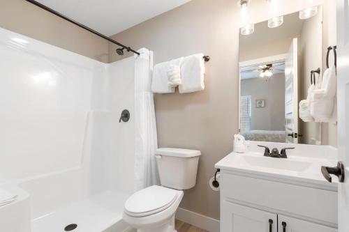 a white bathroom with a toilet and a sink at Timber's Edge in Kimberling City