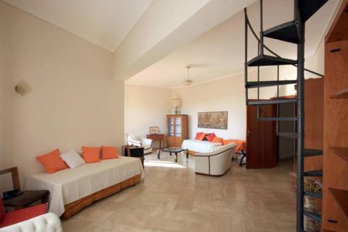 a large room with a bed and a spiral staircase at Casa Vacanze Catalano in Erice