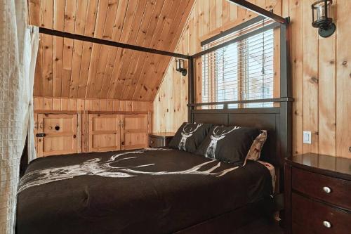 a bedroom with a bed in a wooden cabin at Nouveau - 3CH : Ski-in / Ski-out & foyer in Saint-Apollinaire