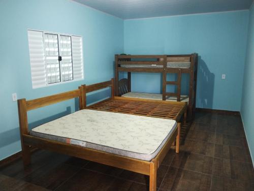 a bedroom with two bunk beds and a window at Chácara Rodrigues in Piedade