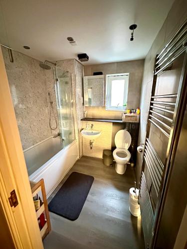 a bathroom with a toilet and a tub and a sink at Escape Homestay 