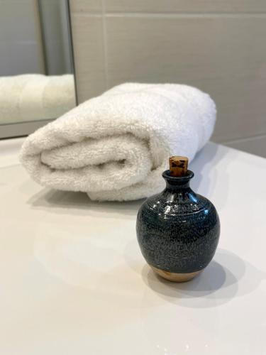 - une serviette et un vase dans la salle de bains dans l'établissement Villa Caprice à l'orée des bois, à Aspres-sur-Buëch