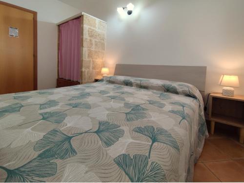 una camera da letto con un letto con un piumone colorato di Il Geco b&b a Gallipoli