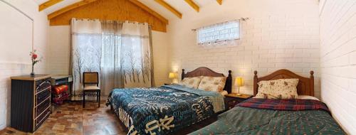 Encantadora Casa con Balcón a Pasos del Mar في لاس كروسيس: غرفة نوم بسريرين ومكتب ونافذة