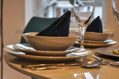 a wooden table with plates and bowls with napkin in them at The Sashes - Cozy Apartment - FREE Parking - Ultrafast WIFI - Smart TV - Netflix - sleeps up to 6! Close to Poole Town Center & Sandbanks & Bournemouth in Poole