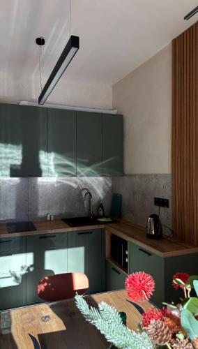 a kitchen with green cabinets and a wooden table at Котедж Gudz in Yaremche