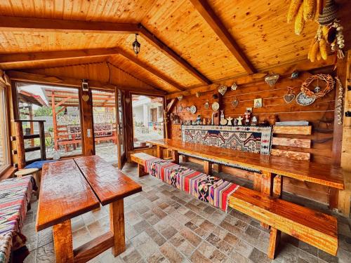 a dining room with wooden tables and benches at Casa Andreas in Zărneşti