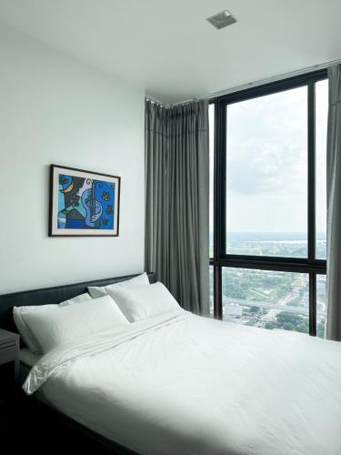 una camera con un grande letto e una grande finestra di HMJ1 Entire Apt on 31th floor in Khonkaen city center a Ban Si Than