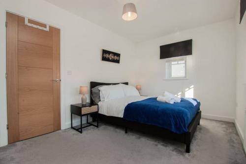 a bedroom with a bed with a blue bedspread at Charming Colchester House in Colchester