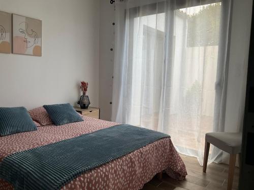 une chambre avec un lit et une grande fenêtre dans l'établissement Maison Liséna, à Périgny