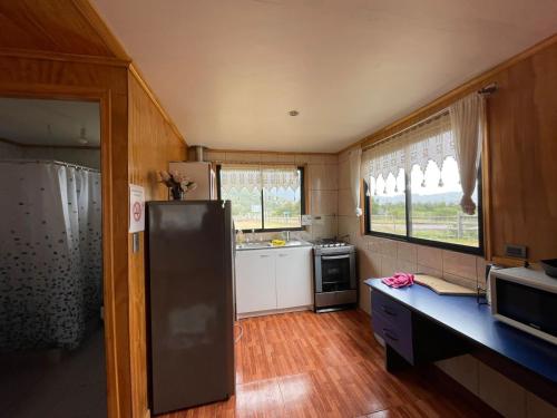uma pequena cozinha com um frigorífico e uma janela em Cabañas El Diamante em Villa Maniguales