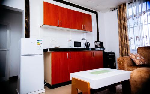 a kitchen with red cabinets and a white refrigerator at DOMINGO VILLA in Dar es Salaam