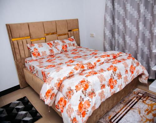 a bedroom with a bed with an orange and white comforter at DOMINGO VILLA in Dar es Salaam