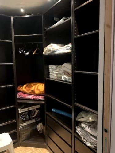 um closet com prateleiras pretas e toalhas em Appartement chic em Villejuif