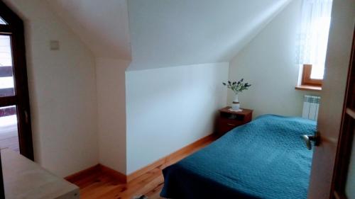 a bedroom with a blue bed and a window at Enklawa Spokoju in Słójka Borowszczyzna