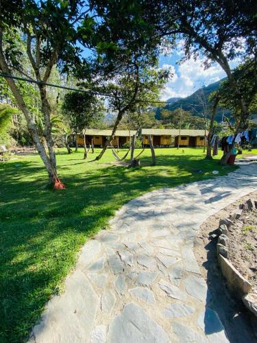 a park with trees and a swing set in the grass at LA HACIENDA LODGE in Santa Teresa