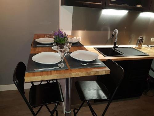 a kitchen with a table with plates and wine glasses at (Nouvelles literie)ménage gratuit in Bayonne
