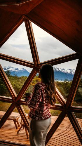 a woman standing in front of a large window at Estancia Patagonia El Calafate - Pristine Luxury Camps in El Calafate