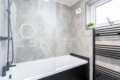 a bathroom with a bath tub and a window at Modern 1 Bed Studio Flat Leeds in Headingley
