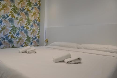 Una cama blanca con dos toallas encima. en Albir Beach & Sea Apt en Albir