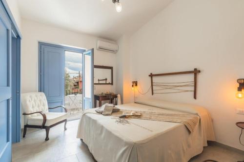 1 dormitorio con 1 cama, 1 silla y 1 ventana en B&B Antico Telaio, en Santa Maria Navarrese