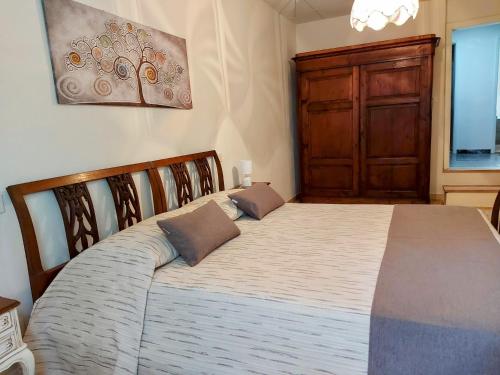 a bedroom with a large bed with a wooden headboard at La Casa sulle Mura - Montecarlo - A 15 km da Lucca in Montecarlo