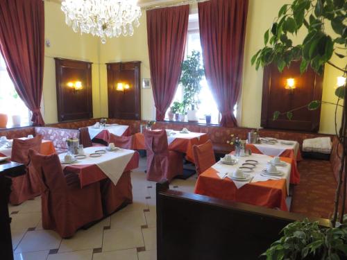 ein Restaurant mit Tischen und roten Tischdecken in der Unterkunft Hotel Pension Stadtpark in Wien