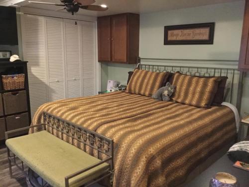 un osito de peluche sentado en una cama en un dormitorio en The Charleston Inn Hendersonville NC, en Hendersonville