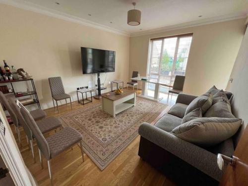 a living room with a couch and chairs and a tv at Entire 1 bed apartment-Convenient and peaceful amenable stay in London