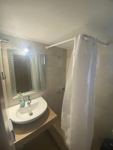 La salle de bains est pourvue d'un lavabo et d'un miroir. dans l'établissement Dimitris Rooms, à Asvestokhórion