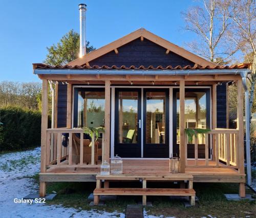 a tiny house with a porch and glass windows at BenB Huys de Landerije in Wouwsche Plantage