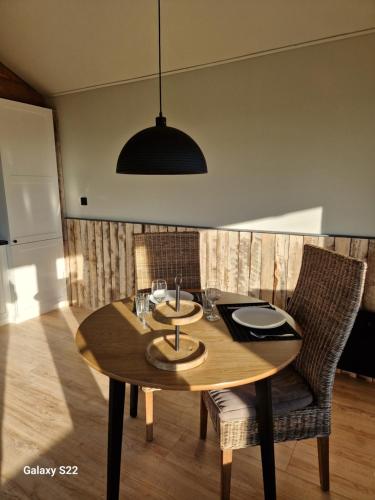 a wooden dining room table with chairs and a pendant at BenB Huys de Landerije in Wouwsche Plantage
