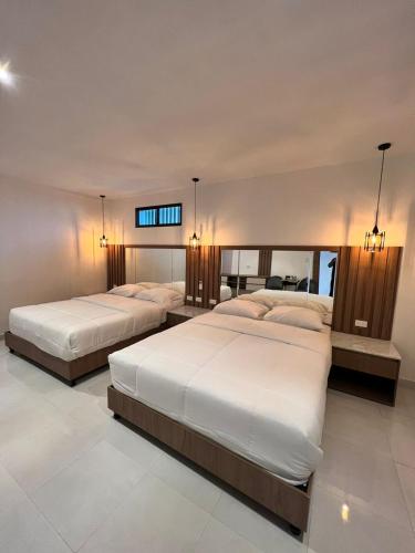 two beds in a large room with at NOVAPARK ILANES in Guayaquil