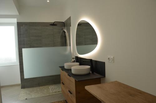 ein Badezimmer mit 2 Waschbecken und einem Spiegel in der Unterkunft Gîte Koala in Marans
