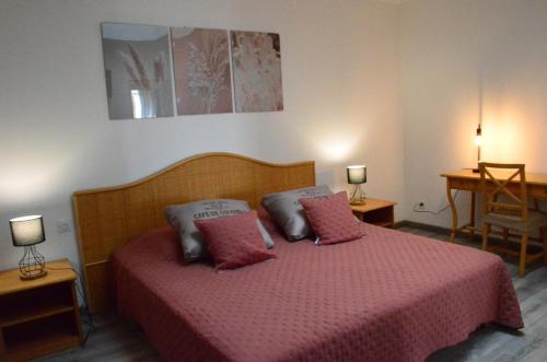Schlafzimmer mit einem Bett mit rosa Bettwäsche und Kissen in der Unterkunft Gîte Koala in Marans