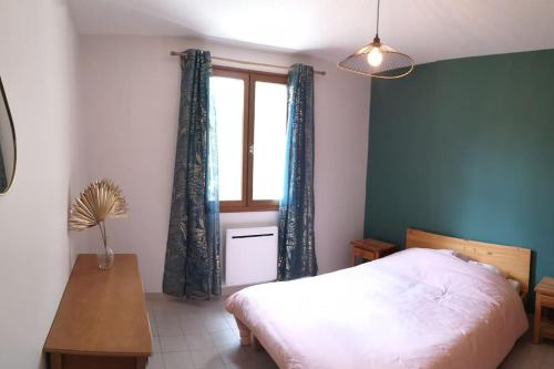 Schlafzimmer mit einem Bett, einem Fenster und einem Tisch in der Unterkunft maison le Rossignol in Châtillon-en-Diois