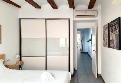 a bedroom with white walls and a sliding glass door at Flats Friends Tetuan in Valencia