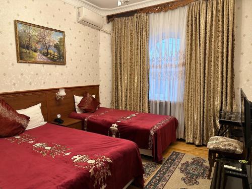 a hotel room with two beds and a window at Sarbon Hotel Tashkent in Tashkent